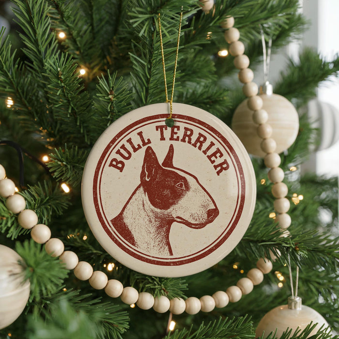 A Christmas tree decorated with ornaments, including a circular ornament with a bull terrier image and the text "Bull Terrier" on it.
