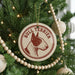 A Christmas tree decorated with ornaments, including a circular ornament with a bull terrier image and the text "Bull Terrier" on it.