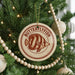 A Christmas tree decorated with ornaments, including a circular ornament with a butterflyfish design and a string of wooden beads.