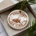 A white ornament with a brown seal and the text "CALIFORNIA SEA LION" is displayed in a box, surrounded by pine branches.