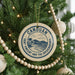 A Christmas tree decorated with ornaments, including a circular ornament with the text "CANOUAN SAINT VINCENT AND THE GREEMENADINES" and a palm tree illustration.