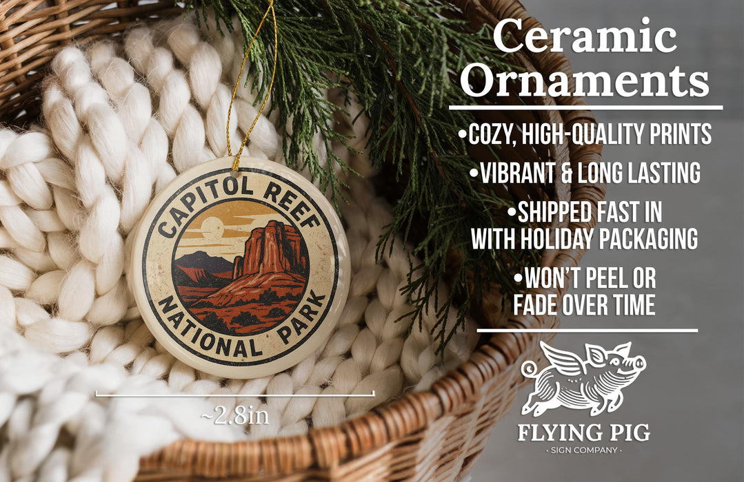 Ceramic ornaments, specifically the Capitol Reef National Park ornaments, are displayed in a woven basket. The text highlights the ornaments as cozy, high-quality prints with vibrant and long-lasting vibrancy, and they are shipped fast in holiday packaging, preventing peeling or fading over time. The image also features a logo for the Flying Pig sign company.