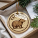 A round ornament with the word "CAPYBARA" printed on it, featuring an illustration of a capybara.