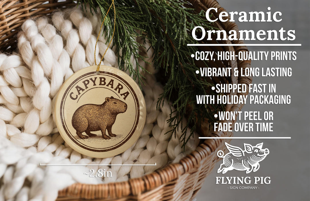 Ceramic ornaments, specifically a ceramic Cappbara ornament, are displayed in a wicker basket. The ornament features a brown pig illustration and is described as a cozy, high-quality print, vibrant, and long-lasting, and shipped fast in holiday packaging. The ornament is not peeling or fading over time.