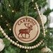 A Christmas tree decorated with ornaments, including a circular ornament with a deer image and the word "CARIBOU" written on it.