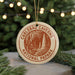 A circular ornament with the text "CARLSBAD CAVENS NATIONAL PAPARK" printed on it, hanging from a string.