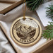 A circular ornament with a mountain landscape and pine trees, featuring the text "CARPATHIAN MOUNTAINS ROMANIA" on it, is displayed in a box with pine branches.