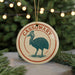 A circular ornament with the word "CASSOWARY" written on it, featuring a stylized illustration of a bird.