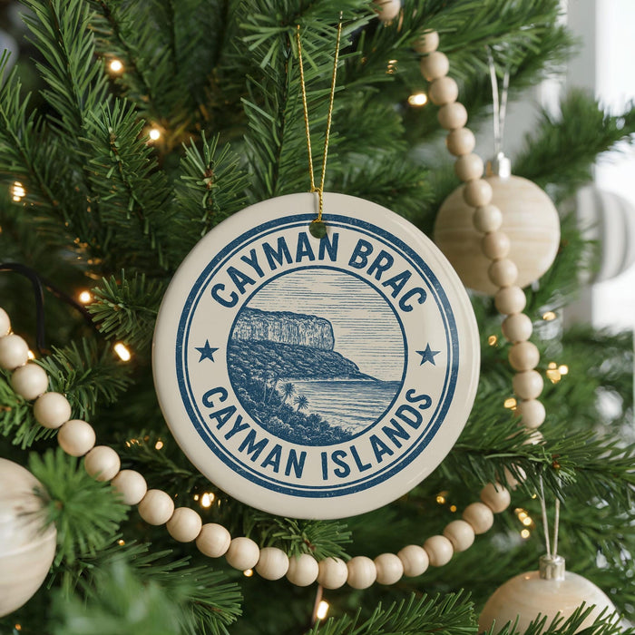 A circular ornament on a Christmas tree, featuring the text " Cayman Islands" and a graphic of a tropical island landscape.