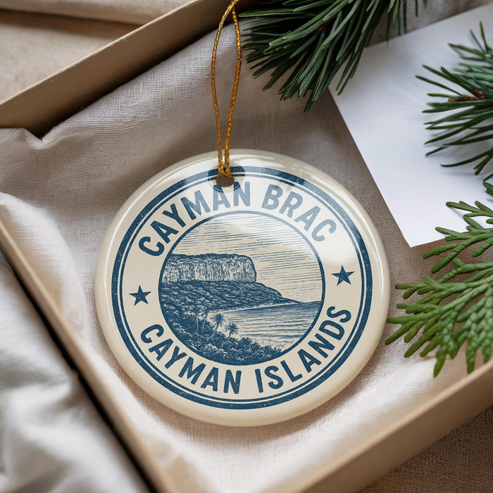 A circular ornament with the text " Cayman Brac Cayman Islands" printed on it, hanging from a string.