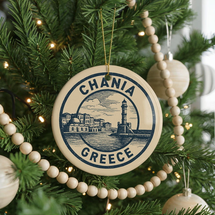 A circular ornament on a Christmas tree, featuring the text "CHANIA GRECE" and an illustration of a lighthouse and buildings.