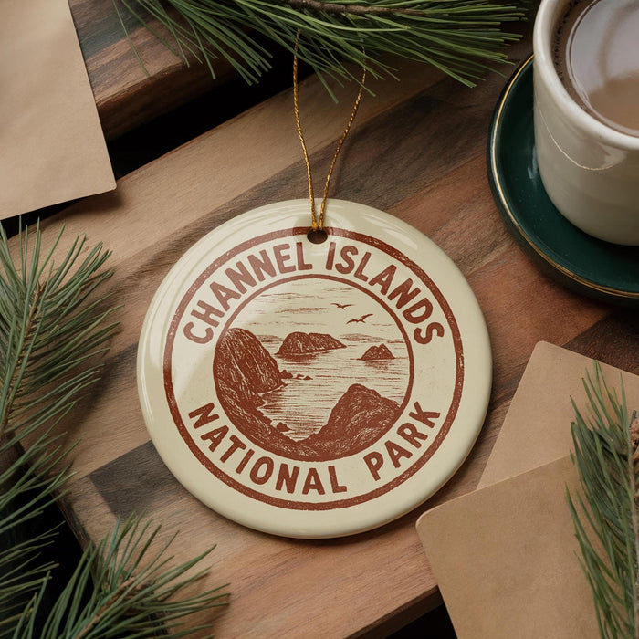 A round ornament with the text "Channel Islands National Park" is displayed on a wooden surface, surrounded by pine branches and a cup of coffee.