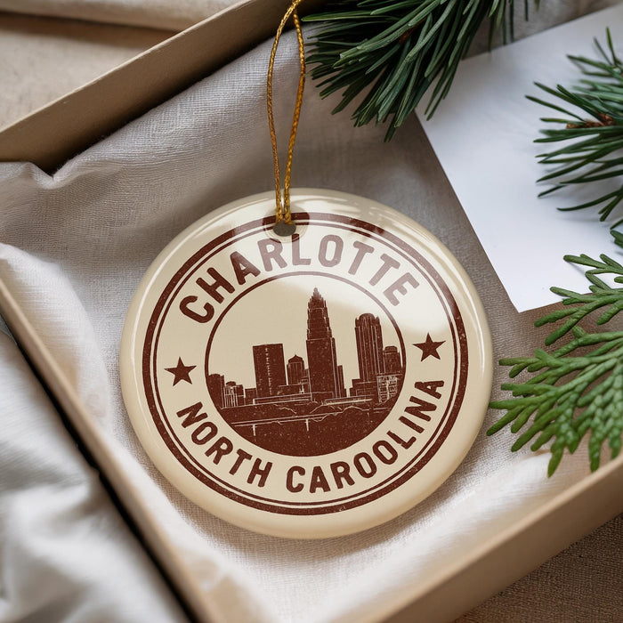 A circular ornament with the text "CHARLOTTE NORTH CAROLINA" printed on it, surrounded by a decorative string.