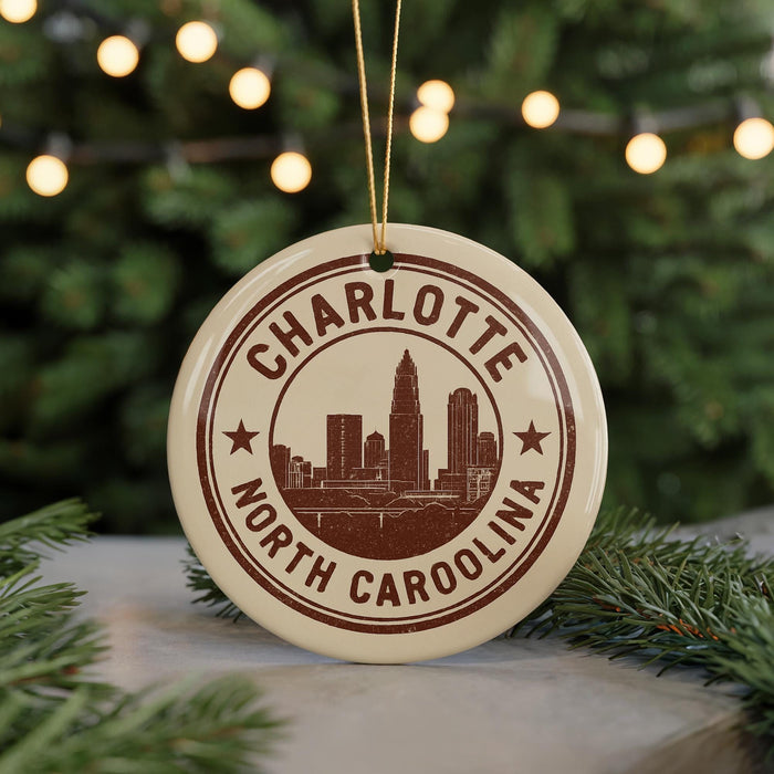 A circular ornament with the text "CHARLOTTE NORTH CAROLINA" and a graphic of a city skyline, hanging from a string.