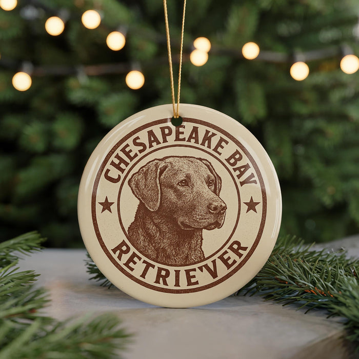 A round ornament featuring a brown dog's head, with the text "CHESAPEAKE BAY RETRIEVER" printed on it, hanging from a string.