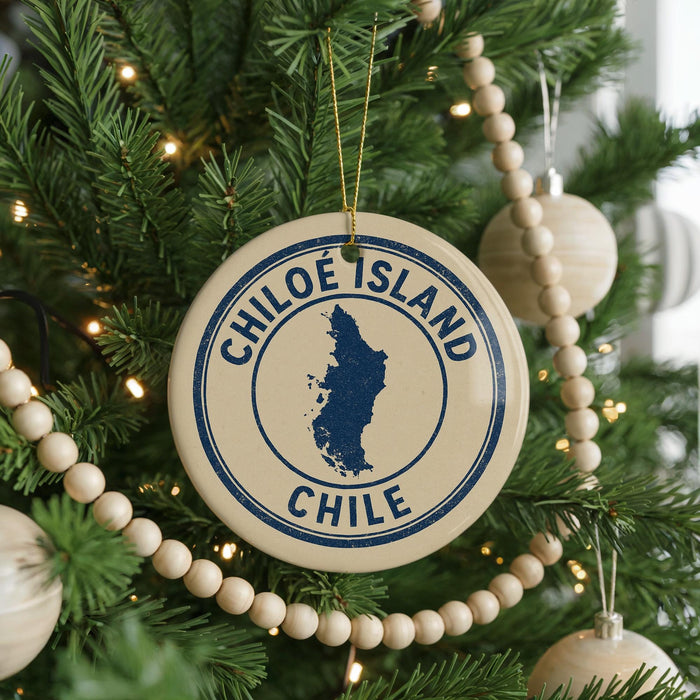 A Christmas tree decorated with ornaments, including a circular ornament with the text "CHILE" and a map of Chile.