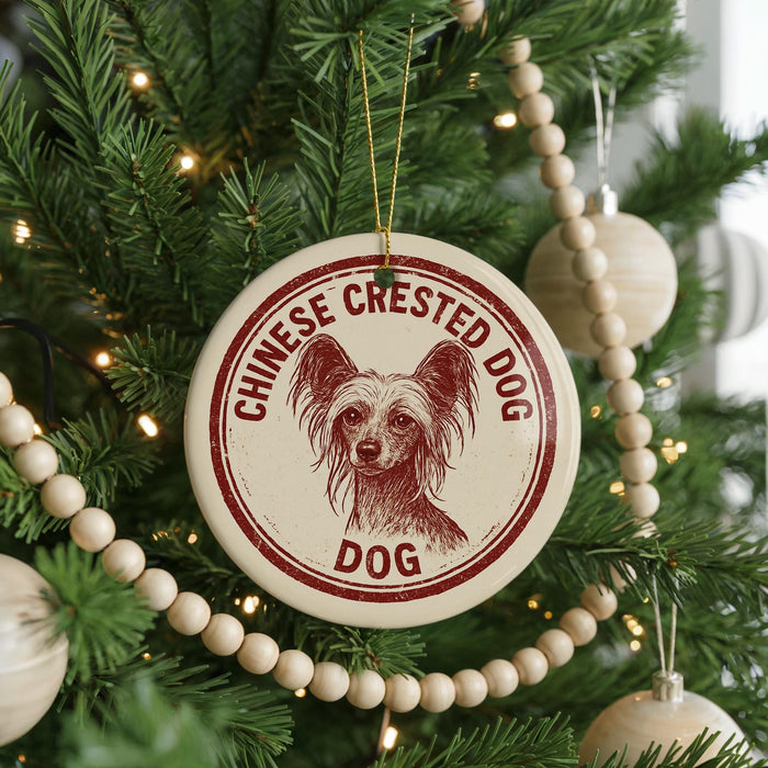 A Christmas tree decorated with ornaments, including a circular ornament with a dog image and the text "CHINESE CREsted DOG" printed on it.