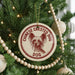A Christmas tree decorated with ornaments, including a circular ornament with a dog image and the text "CHINESE CREsted DOG" printed on it.