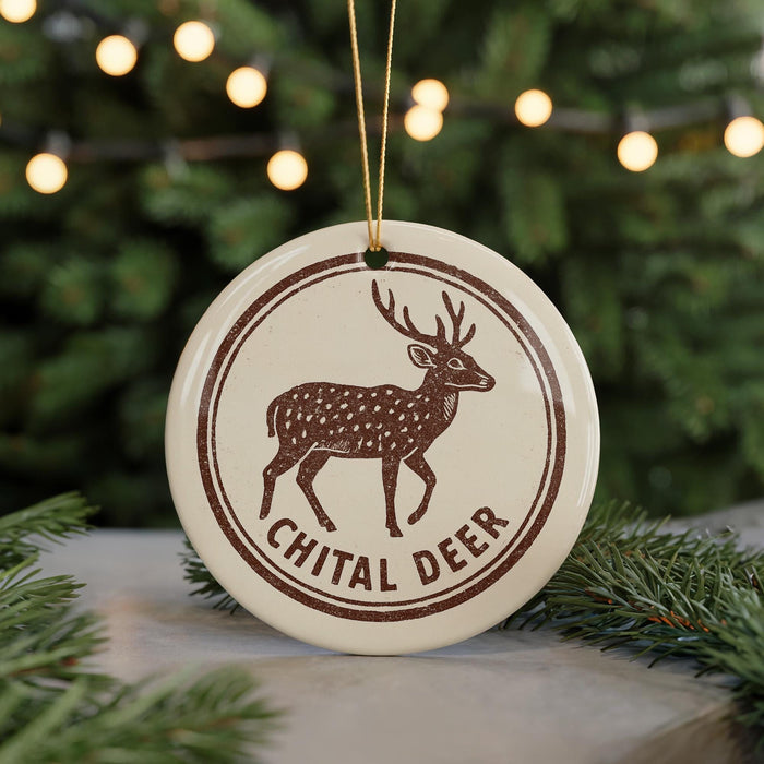 A round ornament with a deer image and the text "CHITAL DEER" on it, hanging from a string.
