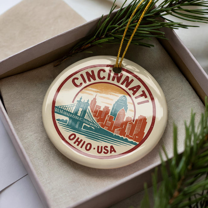 A decorative ornament featuring the city of Cincinnati, Ohio, with a bridge and skyline in the background.