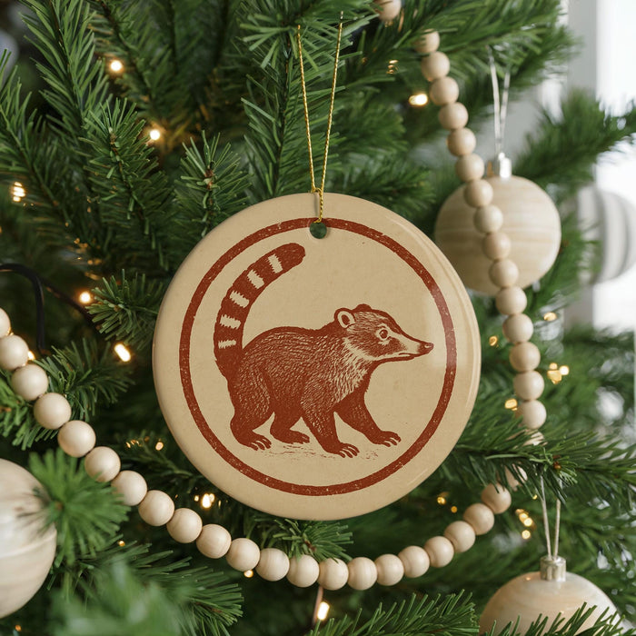 A Christmas tree decorated with ornaments, including a circular ornament featuring a raccoon silhouette.