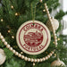 A Christmas tree decorated with ornaments, including a circular ornament with the text "COIMBRA PORTUGAL" on it.