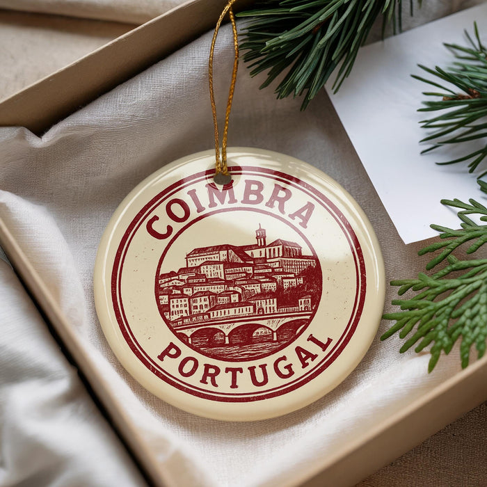 A decorative ornament with the text "COIMBRA PORTUGAL" on it, hanging from a string.