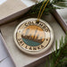 A circular ornament with the text "COLOMBO SRI LANKA" and an illustration of a city skyline, placed in a box with pine branches.