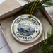A decorative ornament in a box, featuring a mountain landscape and the text "COLORADO SPRINGS COLORADO USA".