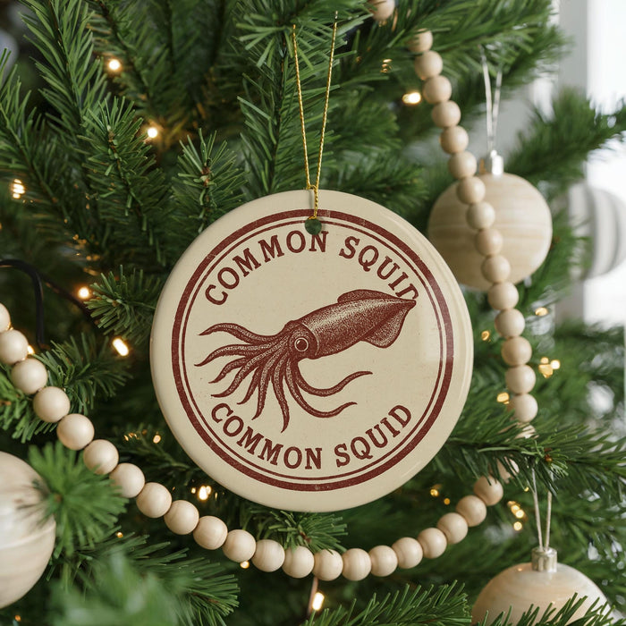 A Christmas tree decorated with ornaments, including a round ornament with the text "COMMON SQUID" and an illustration of an octopus.