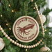 A Christmas tree decorated with ornaments, including a round ornament with the text "COMMON SQUID" and an illustration of an octopus.