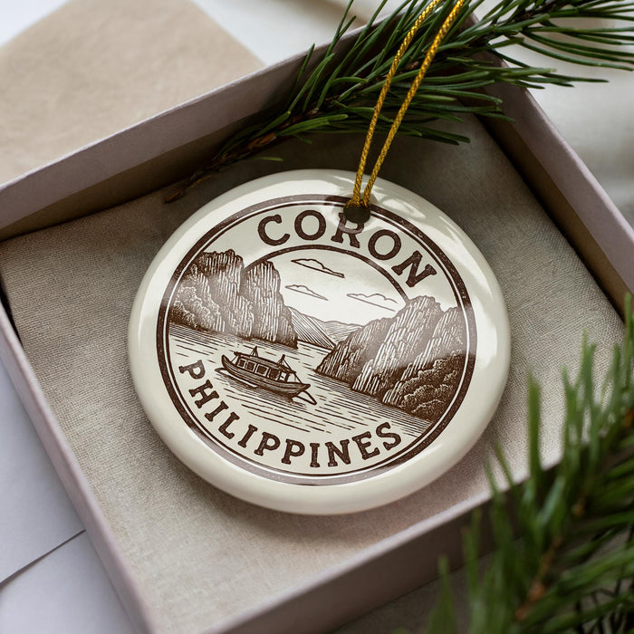 A decorative ornament in a box, featuring a boat and mountains, with the text "CORON PHILIPPINES" prominently displayed.