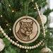 A Christmas tree decorated with ornaments, including a circular ornament featuring a close-up of a cougar's face.