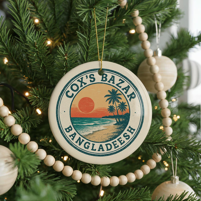 A circular ornament on a Christmas tree, featuring a tropical beach scene with palm trees and a sunset.