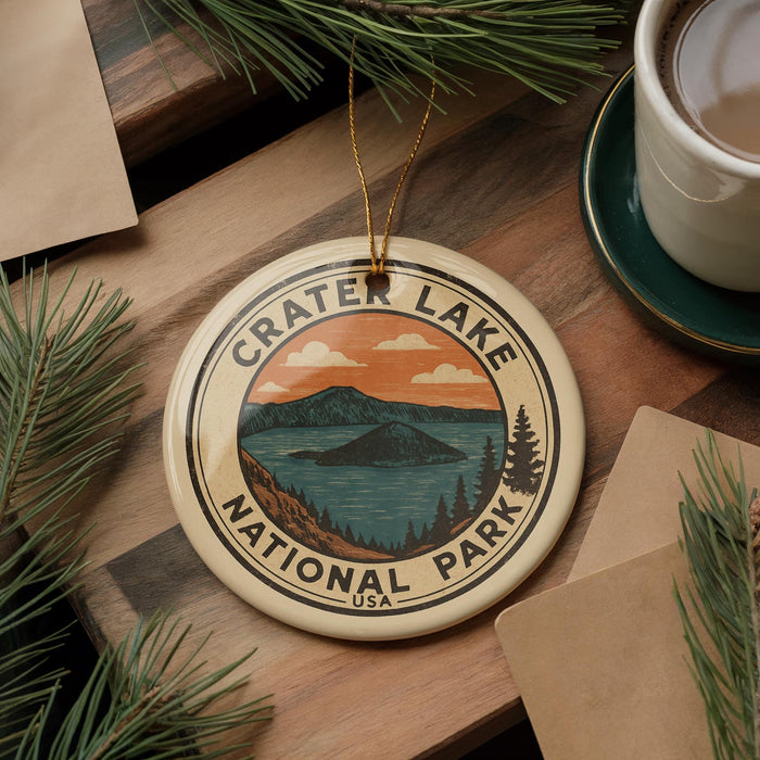 A circular ornament with the text "Crater Lake National Park" and an illustration of a lake surrounded by mountains, pine trees, and a sunset sky.