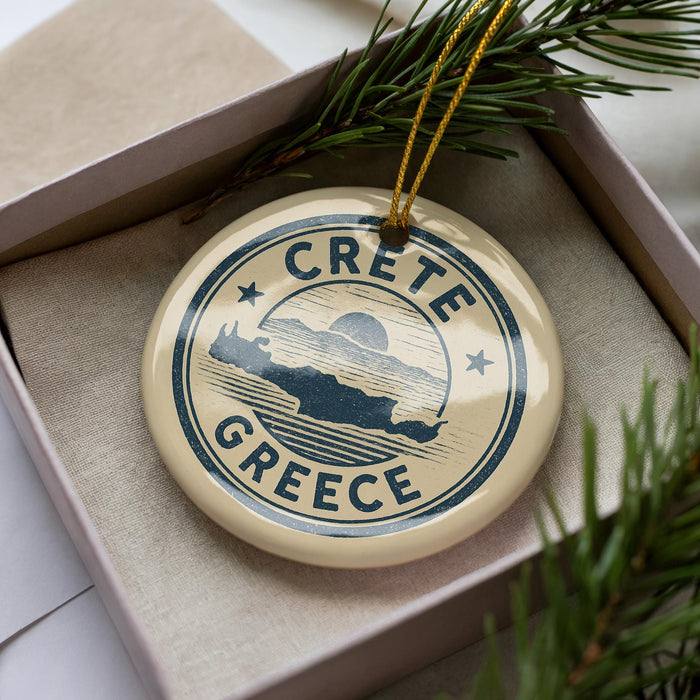 A circular ornament with the text "CRETE GREECE" on it, surrounded by pine branches.