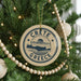 A circular ornament on a Christmas tree with the text "CRETE GREECE" printed on it.