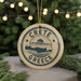 A circular ornament with the text "CRETE GREECE" and a graphic of a map of Crete, Greece, is hanging from a string.