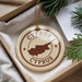 A circular ornament with the text "CYPRUS" and a map of the island of Cyprus, hanging from a string.
