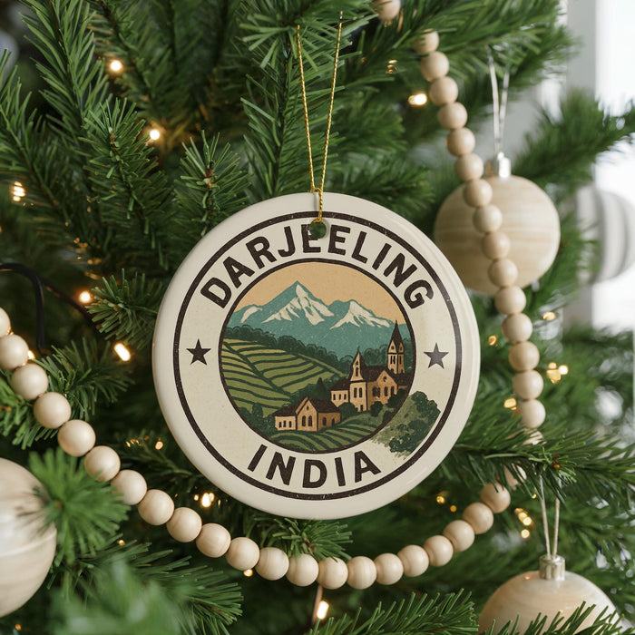 A Christmas tree decorated with ornaments, including a circular ornament with a mountain landscape and the text "DARJEELING INDIA".