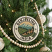 A Christmas tree decorated with ornaments, including a circular ornament with a mountain landscape and the text "DARJEELING INDIA".