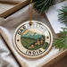 A decorative ornament with the text "DARJELLING INDIA" and a landscape scene featuring mountains, houses, and trees.