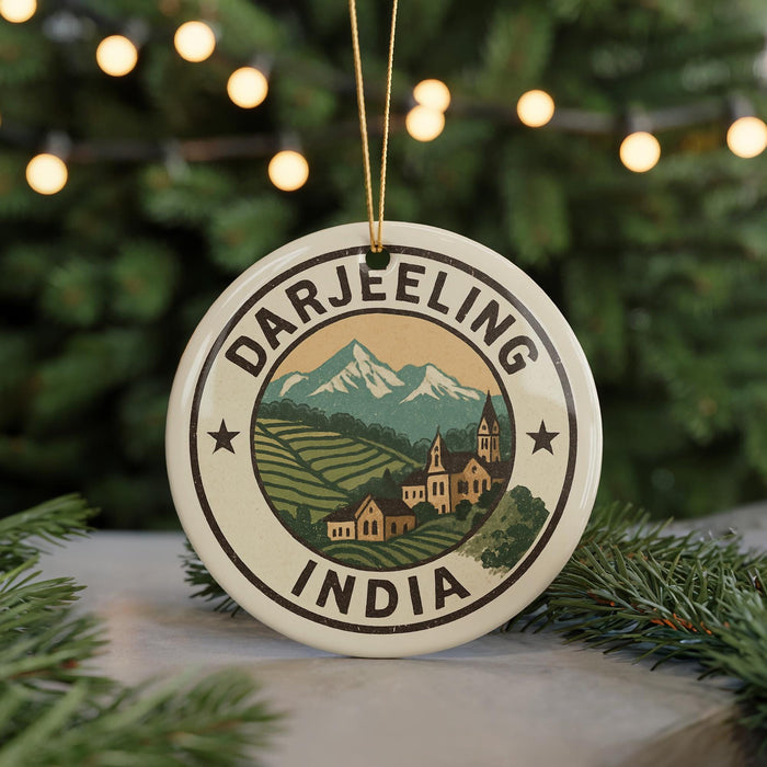 A circular ornament with the text "DARJEELING INDIA" and a mountain landscape design, hanging from a string.