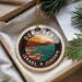 A circular ornament with a design depicting a beach and mountains, surrounded by the text "DEAD SEA ISRAEL JORDAN".