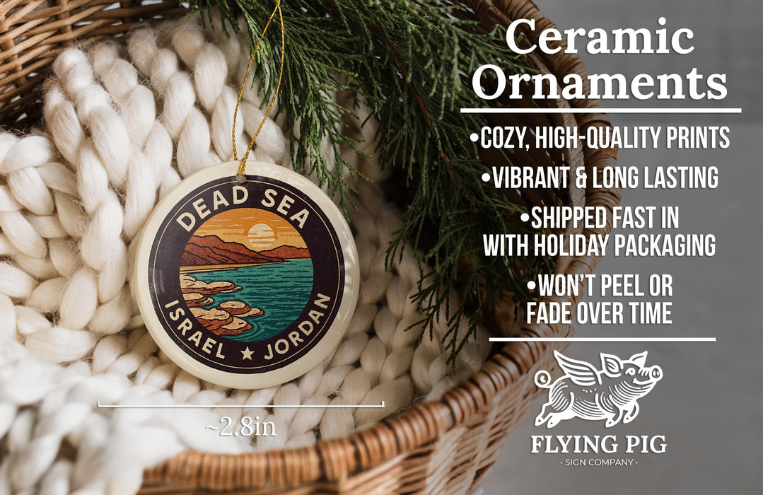 Ceramic ornaments, featuring a design of a sunset over the Dead Sea, are displayed in a woven basket.