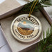 A circular ornament with the text "DEATH VALLEY NATIONAL PARK USA" printed on it, surrounded by pine branches.