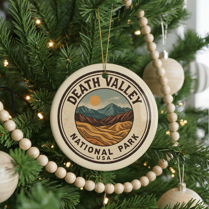 A Christmas tree decorated with ornaments, including a circular ornament with the text "DEATH VALLEY NATIONAL PARK USA" and a landscape illustration.