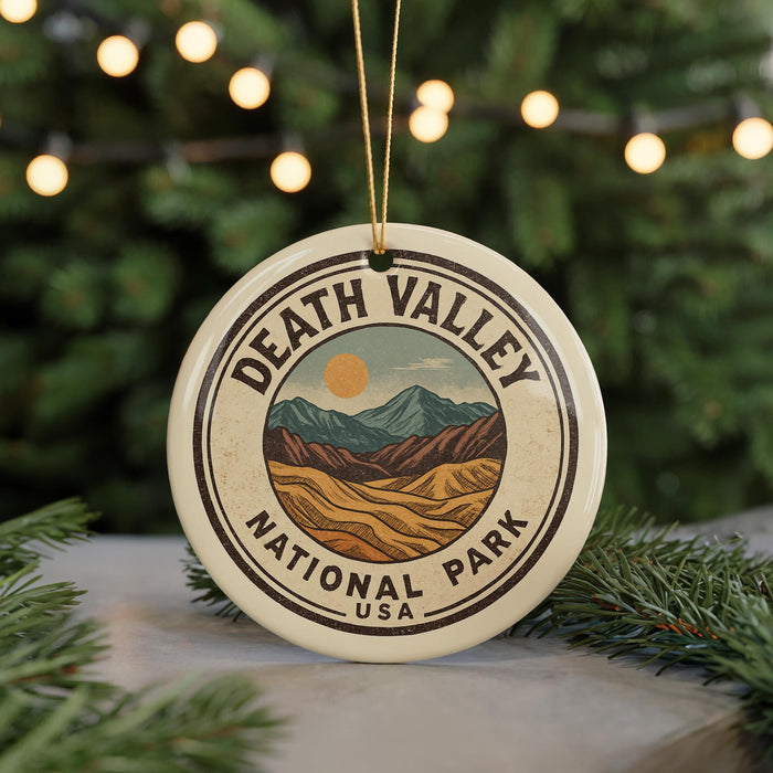 A circular ornament with the text "DEATH VALLEY NATIONAL PARK USA" and an illustration of mountains and a sun, hanging from a string.