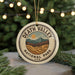 A circular ornament with the text "DEATH VALLEY NATIONAL PARK USA" and an illustration of mountains and a sun, hanging from a string.