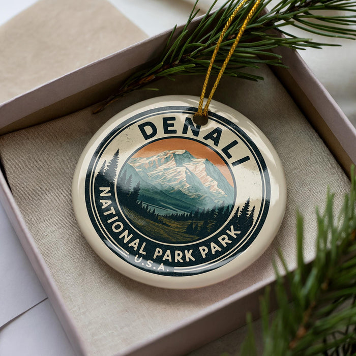 A decorative ornament in a box, featuring a mountain landscape and the text "DENALI NATIONAL PARK USA".